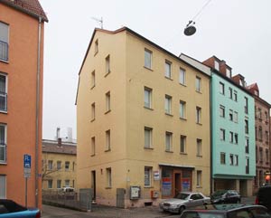 Das Haus Adamstraße 15, ein typisches Beispiel für eine kriegsbedingt vereinfachte und verputzte Altbaufassade.