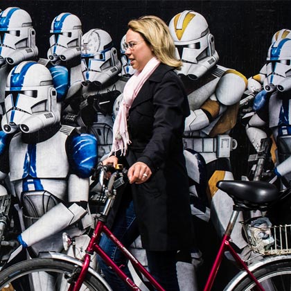 Frau mit Fahrrad vor Robotern